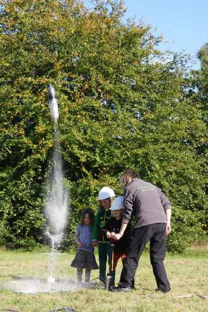 Lemonade bottle rocket flying leaving a jet of water behind it. Part of the Rocket Lab activity from the Freelance Ranger