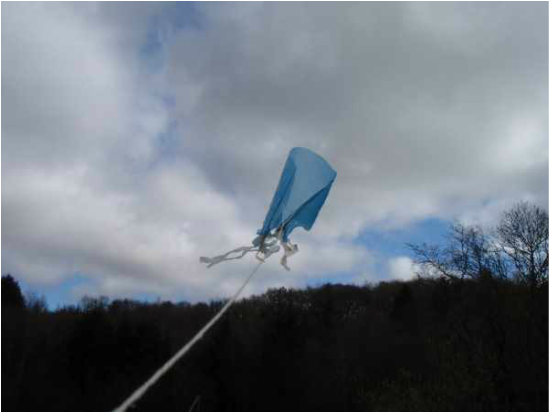 Blue plastic bag kite flying against the sky