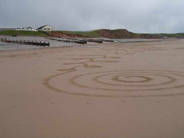 Spiral pattern raked into the beach with groins and shingle beach behind